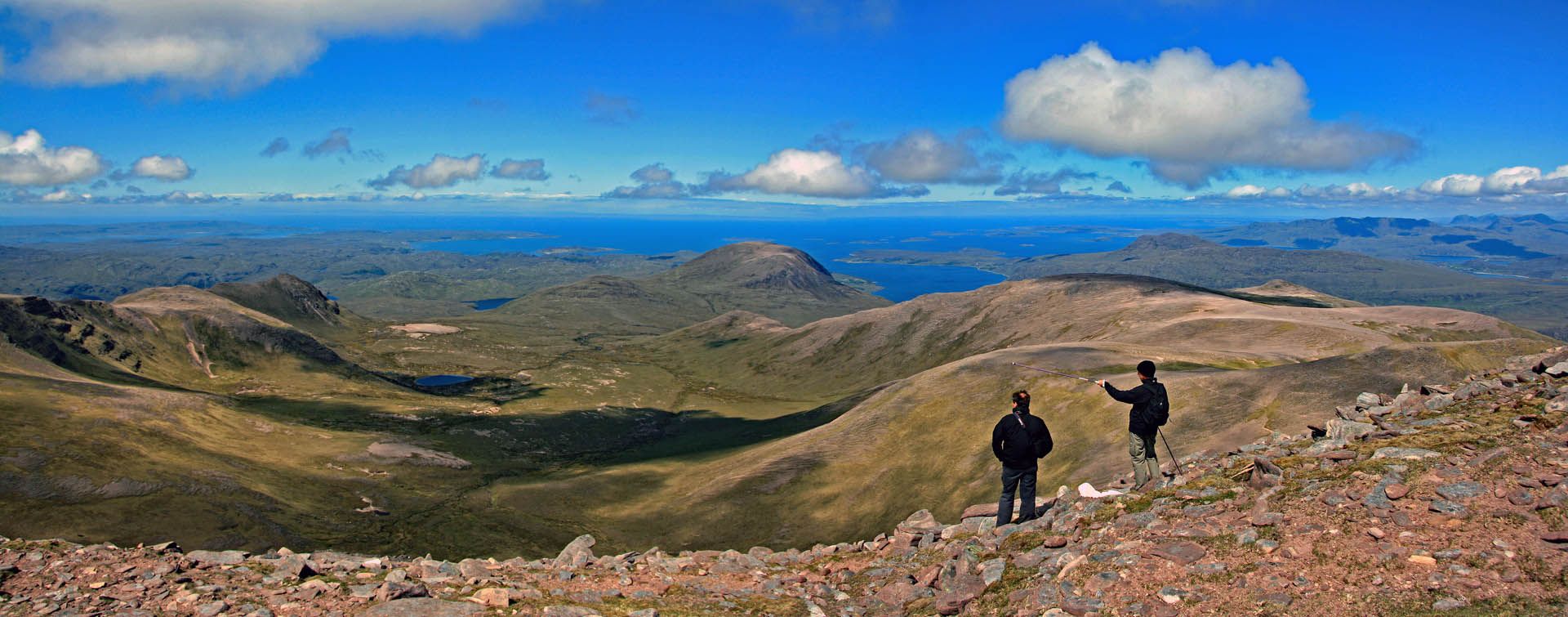 A picture of An Teallach, Gairloch. The picture includes two hikers looking towards the sea.