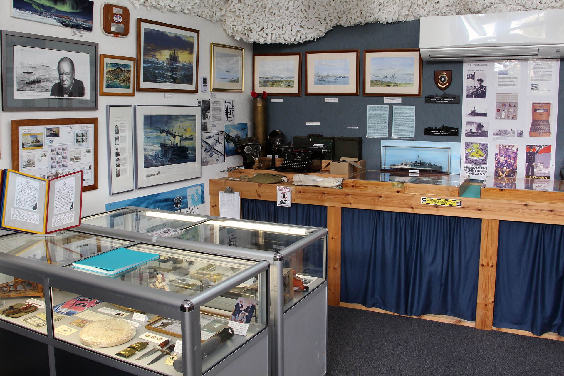 A picture of an exhibition within the Arctic Convoy Museum Aultbea, Gairloch. The picture features artifacts and pictures relating to wartime events.