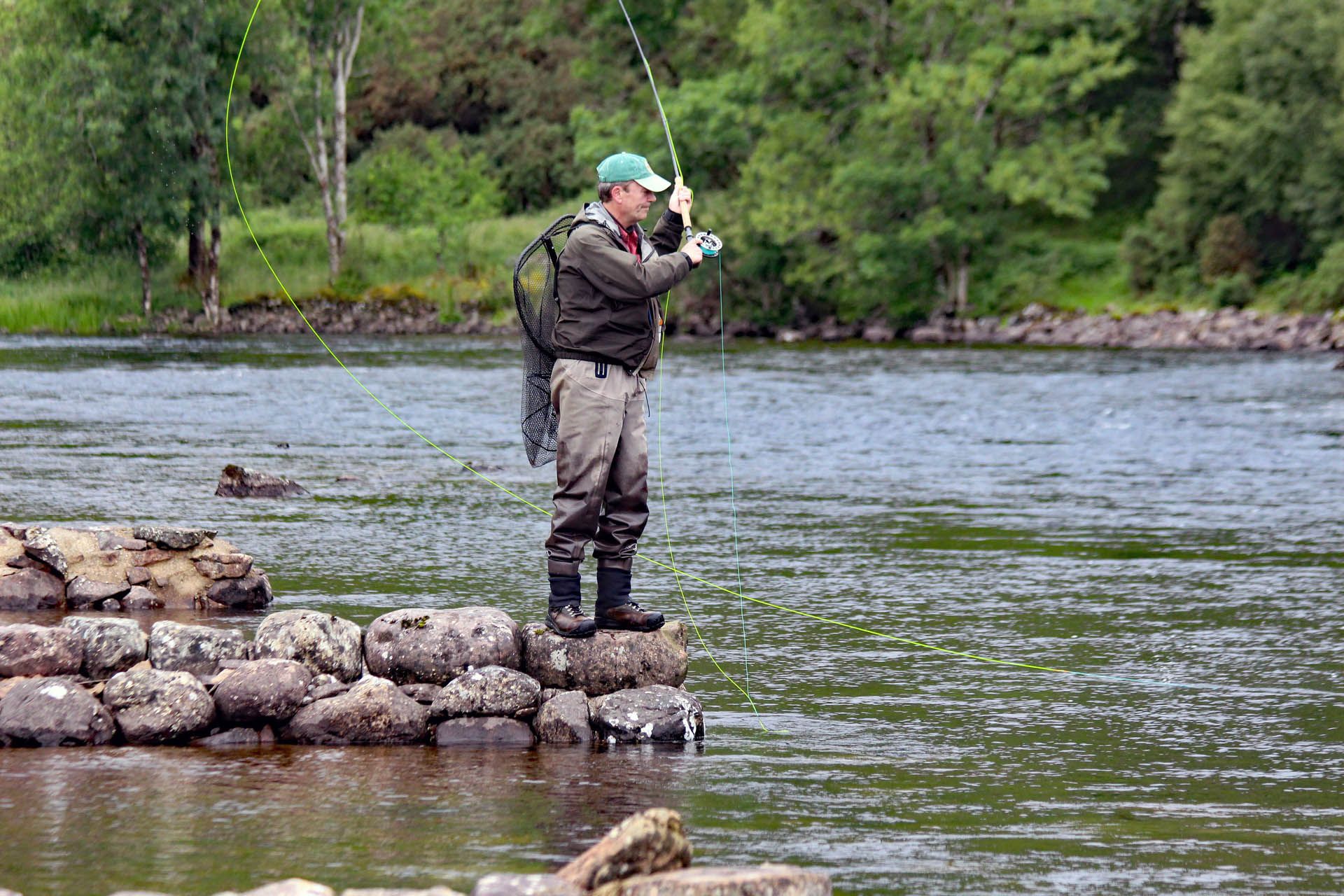This is a picture of a man fishing for Salmon in the River Ewe, Gairloch